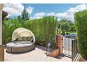Comfortable outdoor seating area with a cozy daybed, surrounded by lush greenery and privacy fencing at 1922 Via Delle Arti, Henderson, NV 89044