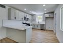 Modern kitchen featuring sleek gray cabinets, stainless steel appliances, and stylish wood floors at 212 View Dr, Las Vegas, NV 89107