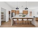Modern kitchen with stainless steel appliances, island with seating, and bright lighting at 2297 Aria Dr, Henderson, NV 89052