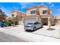 View of the home exterior highlighting the driveway, two-car garage and desert landscaping at 309 Clifton Heights Dr, Las Vegas, NV 89145