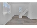 Bright living room featuring wood-look floors, staircase, and fresh white paint at 3741 Cactus Wheel Ct, Las Vegas, NV 89129