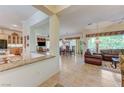 Open concept living and dining area with tile flooring, granite countertops, and lots of natural light at 4636 Riva De Romanza St, Las Vegas, NV 89135