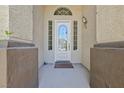 Close-up of the front door with decorative glass, sidelights, and textured stucco walls at 4724 Stavanger Ln, Las Vegas, NV 89147