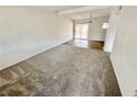 Bright living room with plush carpet, a ceiling beam, and glass sliding doors at 4924 Carmen Blvd, Las Vegas, NV 89108