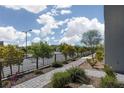 Landscaped street view with sidewalk, street lamps, and lush green trees at 494 Mahogany Ridge St, Las Vegas, NV 89138