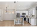 Well-lit kitchen with stainless appliances, granite counters, breakfast bar, and open-concept layout at 6525 Raven Hall St, North Las Vegas, NV 89084