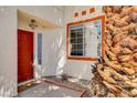 Inviting front entrance with a red door, trimmed window, and a charming 'hello' doormat at 6652 Coral Springs Cir, Las Vegas, NV 89108