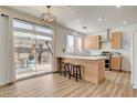 Modern kitchen featuring a central island, wooden cabinets, and a sliding glass door leading to an outdoor patio at 6652 Coral Springs Cir, Las Vegas, NV 89108