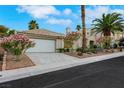 Charming single Gathering home with a well-manicured lawn, colorful flowers, and two-car garage at 7701 Sea Cliff Way, Las Vegas, NV 89128