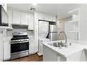 Modern kitchen featuring stainless steel appliances, white cabinetry, and a functional layout at 9572 Belle Rich St, Las Vegas, NV 89123
