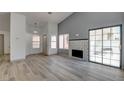 Spacious living room with fireplace, sliding glass doors, and wood-look flooring at 116 Lotus Blossom Ct, Las Vegas, NV 89145