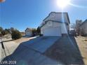 Exterior view of a two-story home with attached garage and detached garage on a clear day at 1745 Starridge Way, Las Vegas, NV 89142