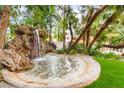 Beautiful backyard water feature with a rock waterfall and lush greenery, creating a peaceful oasis at 226 Dalmatian Ln, Las Vegas, NV 89107