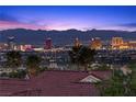 Scenic twilight view of the city skyline and mountain range from this hillside property at 2508 Faiss Dr, Las Vegas, NV 89134