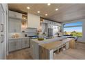 Modern kitchen features custom cabinets, stainless steel appliances, a large island, and views of the valley at 2508 Faiss Dr, Las Vegas, NV 89134