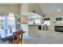 Open floorplan of kitchen and living room with fireplace, views of the patio, and natural light at 2925 Wigwam Pkwy # 1124, Henderson, NV 89074