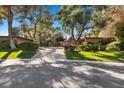 A long driveway leads to this elegant home, complemented by mature trees and manicured landscaping at 2961 Augusta Dr, Las Vegas, NV 89109