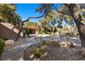 The front yard features mature trees and desert landscaping, creating a welcoming and serene entrance at 2961 Augusta Dr, Las Vegas, NV 89109