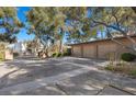 Spacious three-car garage with ample parking space, set amidst mature trees and desert landscaping at 2961 Augusta Dr, Las Vegas, NV 89109