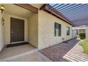 Front porch area with a dark-stained front door, stucco exterior and brick walkway at 3063 Chapala Dr, Las Vegas, NV 89120