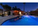 Backyard at dusk features a swimming pool illuminated by string lights with a covered patio and seating area at 3708 Lorraine Ln, Las Vegas, NV 89120