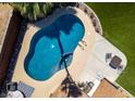 Overhead shot showcases a beautiful, sparkling pool with poolside seating surrounded by well-manicured greenery at 3708 Lorraine Ln, Las Vegas, NV 89120