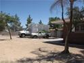 View of driveway area adjacent to the home, with mature trees offering shade on a sunny day at 4950 Burnham Ave, Las Vegas, NV 89119