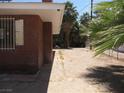 Back exterior view of the brick home, with a sandy yard partially shaded by a mature palm tree at 4950 Burnham Ave, Las Vegas, NV 89119