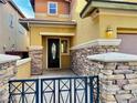 Inviting front porch featuring stone pillars and decorative metal gate leads to an elegant entrance at 5361 Candlespice Way, Las Vegas, NV 89135