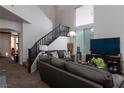 Living room featuring high ceilings, a dark wood stairway, and lots of natural light at 6007 Turtle River Ave, Las Vegas, NV 89156