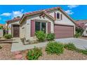 Single-story home featuring desert landscaping, a two-car garage, and a cozy front entrance at 6035 Shadow Oak Dr, North Las Vegas, NV 89031