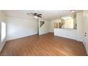 Open-concept living area with wood floors, ceiling fan, and natural light at 6459 Rusticated Stone Ave # 103, Henderson, NV 89011