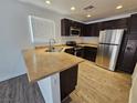 Well-lit kitchen features stainless steel appliances and dark wood cabinetry at 6824 Briarwood Bend Ave, Las Vegas, NV 89130