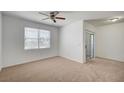 Bright bedroom with a ceiling fan, carpet flooring, and sliding glass door to the balcony at 6955 N Durango Dr # 1093, Las Vegas, NV 89149