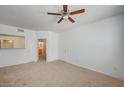 Open-concept living space with neutral carpet, white walls, and view into the bathroom at 6955 N Durango Dr # 1093, Las Vegas, NV 89149