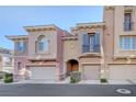 Attractive townhome featuring a private garage, arched entryway, and charming architectural details at 7856 Carysford Ave, Las Vegas, NV 89178
