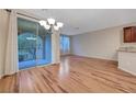 Bright living room with glass sliding door to patio, sleek wood floors, and modern lighting at 7856 Carysford Ave, Las Vegas, NV 89178