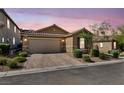 Charming single-story home with a two-car garage, paved driveway, and desert landscaping at dusk at 8346 Vinamala Ave, Las Vegas, NV 89149