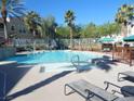 Beautiful community pool with ample seating, shaded areas, and lush palm trees at 9975 Peace Way # 1149, Las Vegas, NV 89147