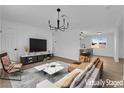 Bright living room featuring an open layout, modern chandelier, and seamless flow into the kitchen, designed for comfortable living at 1108 Putnam Ave, North Las Vegas, NV 89030
