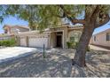 Tan two-story home with three-car garage and low maintenance desert landscaping at 12 Golden View St, Henderson, NV 89012