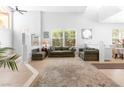 Bright living room with high ceilings, large windows, neutral decor, and comfortable seating at 179 Adomeit Dr, Henderson, NV 89074
