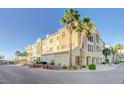 Exterior of a building featuring a beige facade, well-manicured landscaping, and palm trees at 2555 Hampton Rd # 5104, Henderson, NV 89052