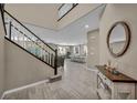 Welcoming entryway featuring stylish tile flooring, a staircase with dark wood accents, and an open view of the living area at 3195 Hazy Hills Ave, Henderson, NV 89052