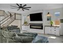 Cozy living room features a fireplace, custom cabinets, a ceiling fan, and comfortable seating at 3195 Hazy Hills Ave, Henderson, NV 89052
