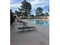 Community pool and lounge area with comfortable seating and lush greenery at 3226 Weber Ct, Las Vegas, NV 89121