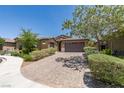 Inviting single-story home boasts a brick driveway, lush greenery, and charming curb appeal at 368 Calabria Beach St, Henderson, NV 89015