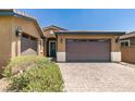 Charming home features a two-car garage, and an arched doorway with neatly trimmed landscaping at 368 Calabria Beach St, Henderson, NV 89015