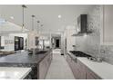 Sleek kitchen with a waterfall island, stainless steel appliances, and stylish pendant lighting at 5 Highland Cove Ln, Henderson, NV 89011
