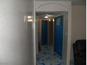 Hallway featuring neutral walls, contrasting blue doors, and unique blue-marbled flooring at 5068 Killarney St, Las Vegas, NV 89122